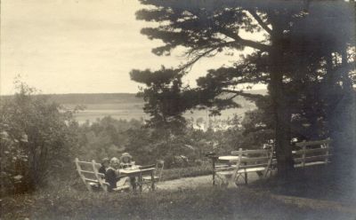 3 flickor sittande vid servering i parkområde
