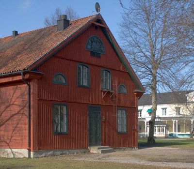 Stor röd byggnad i park
