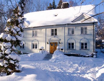 Stort vitt hus i vintermiljö
